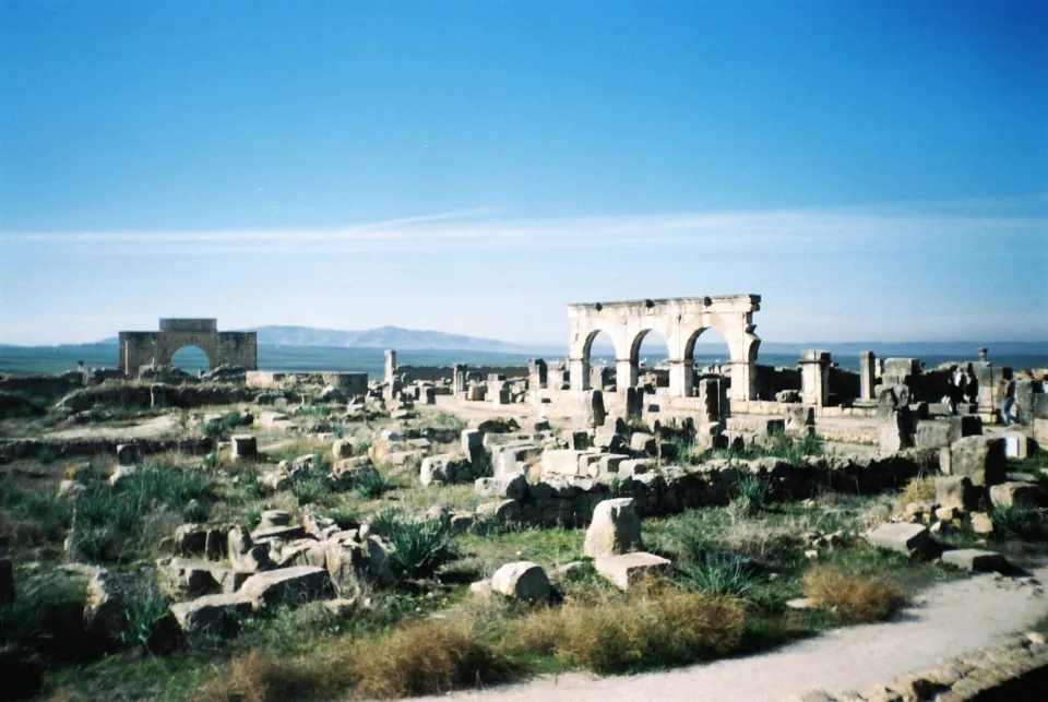 Stone ruins and arches at Volubilis, with low hills behind
